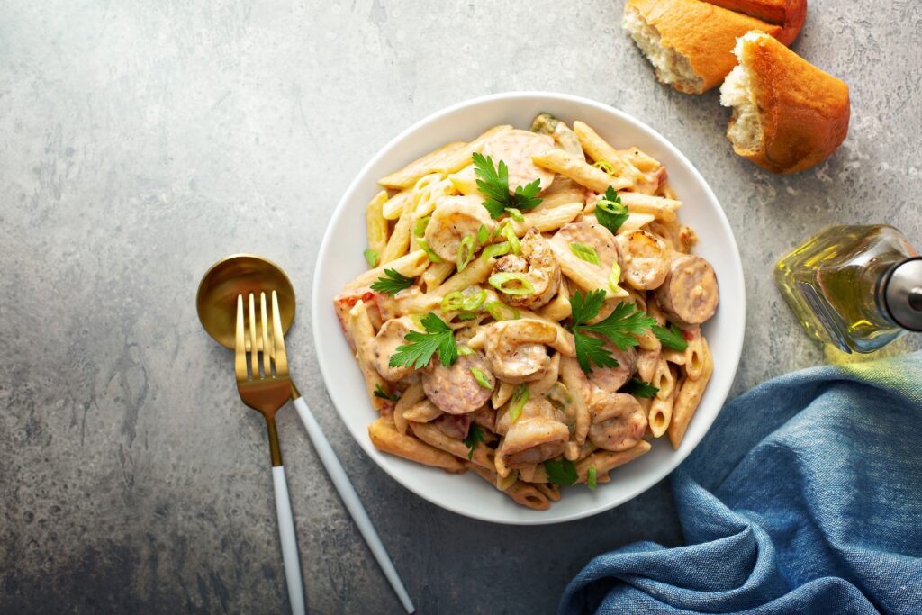 A plate of Cajun Shrimp Pasta with creamy sauce, garnished with fresh parsley and served with a side of crusty bread.