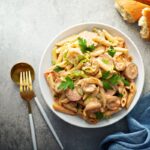 A plate of Cajun Shrimp Pasta with creamy sauce, garnished with fresh parsley and served with a side of crusty bread.