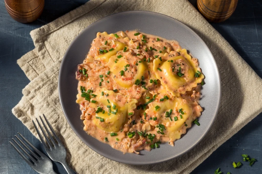 Lobster ravioli with creamy tomato sauce and chives.