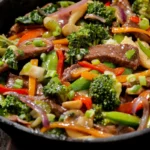 A colorful veggie beef stir fry with broccoli, bell peppers, snap peas, and beef slices.