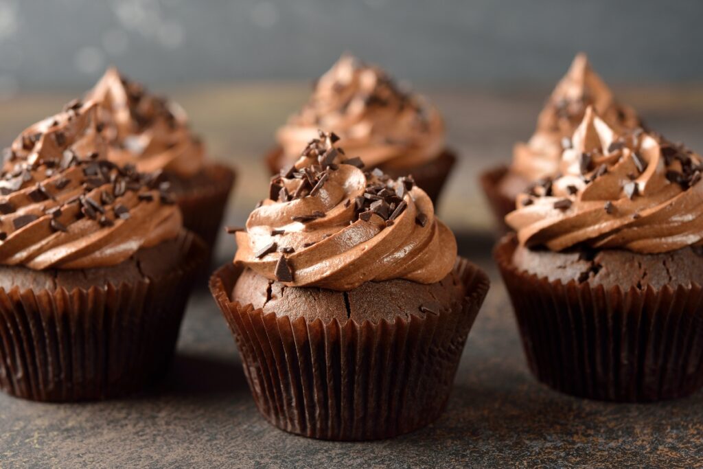 Chocolate pumpkin cupcakes with creamy frosting and chocolate shavings