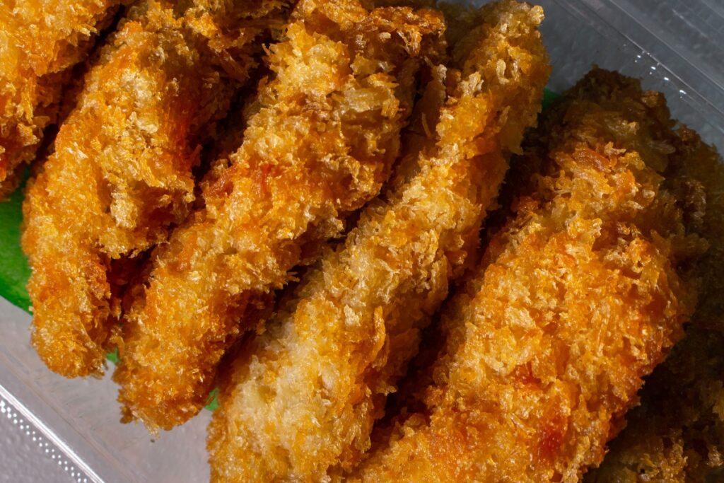  Close-up of crispy golden-brown breaded chicken tenders with a crunchy texture.